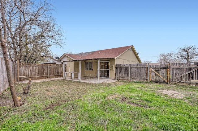 rear view of house with a yard and a patio