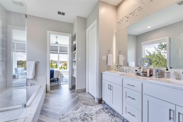 bathroom featuring shower with separate bathtub, ceiling fan, parquet flooring, and vanity