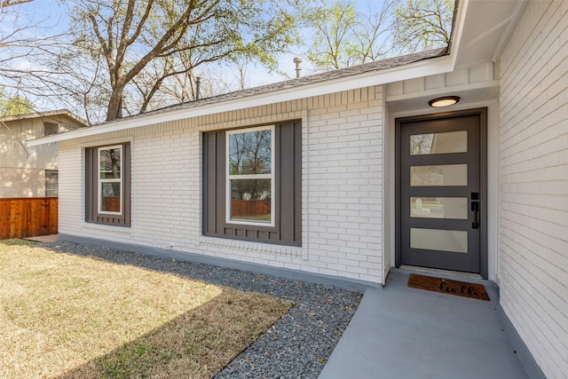 view of exterior entry with a yard