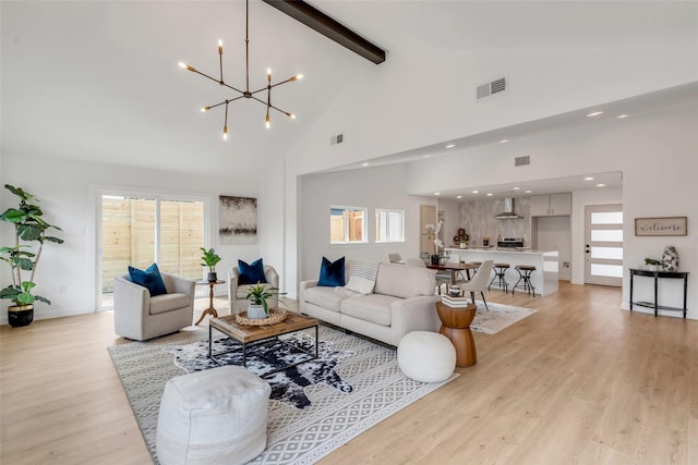 living room with light wood-type flooring, an inviting chandelier, high vaulted ceiling, and beamed ceiling