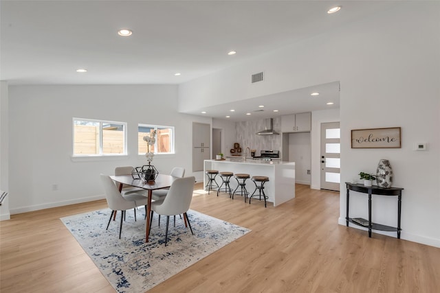 dining area with lofted ceiling and light hardwood / wood-style floors