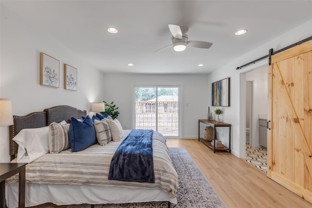 bedroom with access to exterior, ceiling fan, a barn door, and light hardwood / wood-style flooring