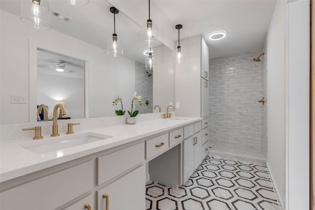 bathroom featuring vanity, tile patterned flooring, ceiling fan, and tiled shower