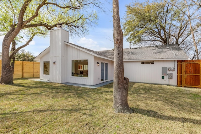 back of house featuring a lawn