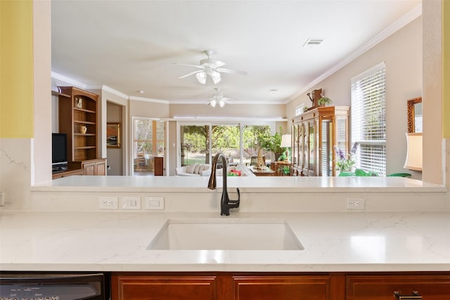 kitchen with sink, ceiling fan, light stone countertops, dishwashing machine, and crown molding