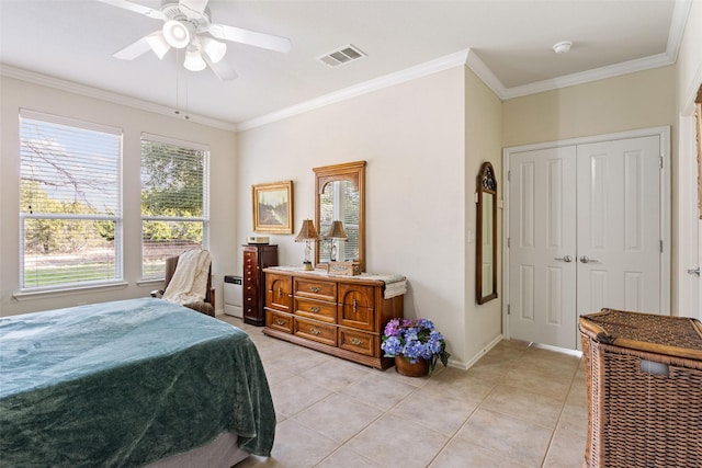 bedroom featuring ornamental molding, light tile patterned flooring, ceiling fan, and a closet