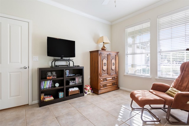 living area with ceiling fan, light tile patterned floors, and crown molding