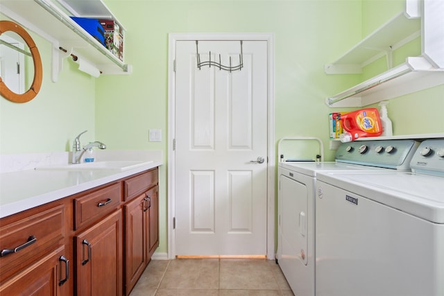 clothes washing area featuring washer and dryer, light tile patterned flooring, and sink