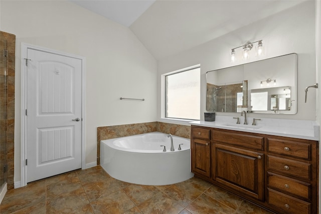 bathroom featuring independent shower and bath, vanity, and vaulted ceiling