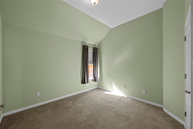 carpeted empty room featuring lofted ceiling