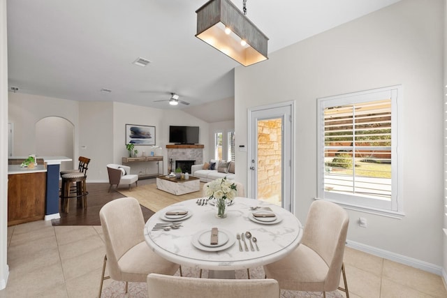 dining space featuring lofted ceiling, light tile patterned flooring, and ceiling fan