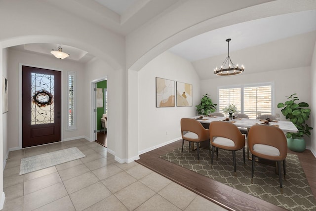 tiled foyer entrance with a notable chandelier