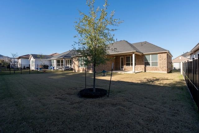 back of house with a lawn and a patio area