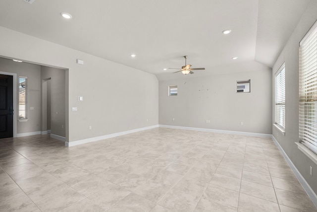 empty room featuring ceiling fan, vaulted ceiling, and light tile patterned floors