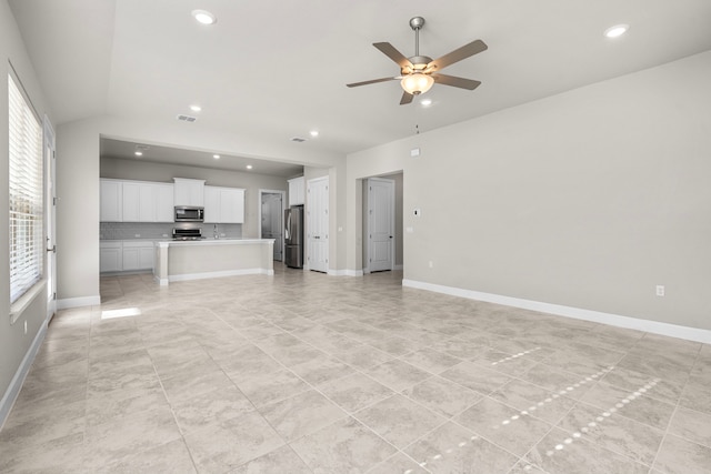 unfurnished living room with vaulted ceiling and ceiling fan