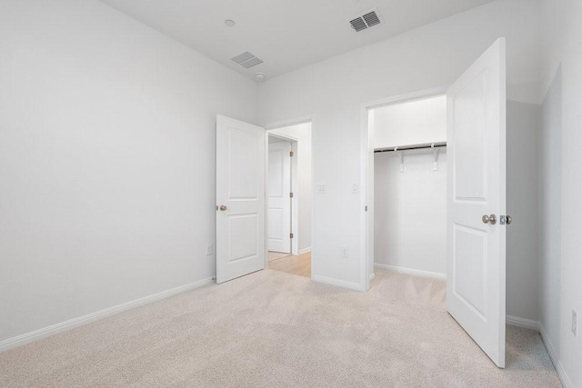 unfurnished bedroom featuring light carpet and a closet