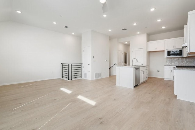 kitchen with dishwasher, an island with sink, light hardwood / wood-style flooring, and white cabinets