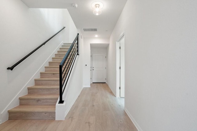 staircase with hardwood / wood-style flooring