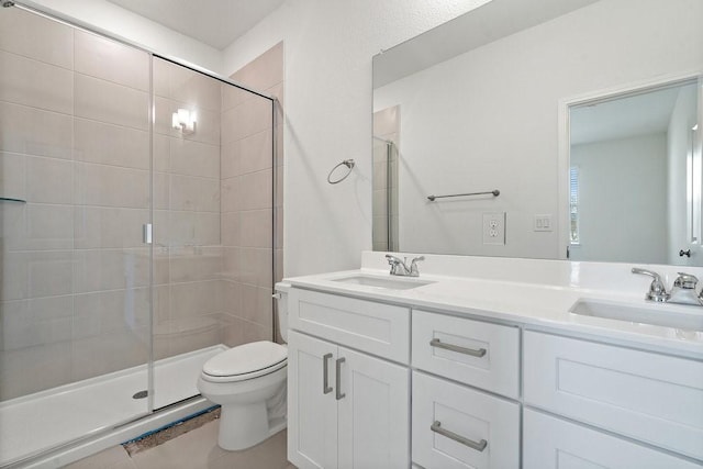 bathroom featuring a shower with door, vanity, and toilet