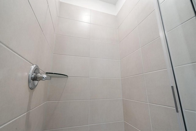 interior details featuring a tile shower