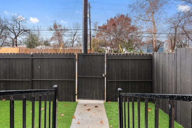 view of gate featuring a yard