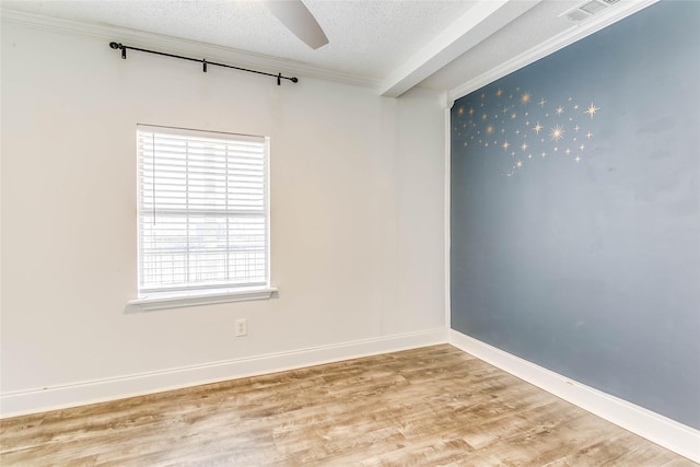 empty room featuring a textured ceiling, hardwood / wood-style floors, ceiling fan, and crown molding