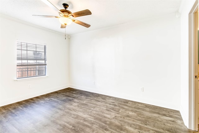 empty room with ornamental molding, ceiling fan, and dark wood-type flooring