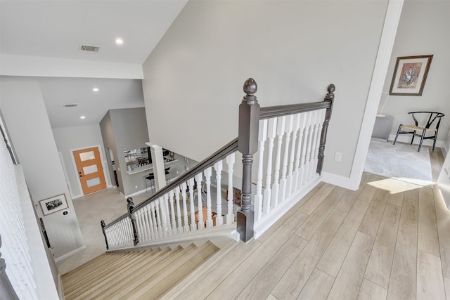 stairs with lofted ceiling and hardwood / wood-style floors