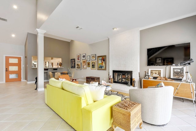 living room with a brick fireplace, high vaulted ceiling, and light tile patterned flooring