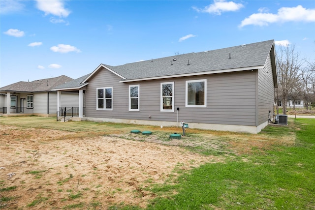 rear view of house featuring a yard and central air condition unit