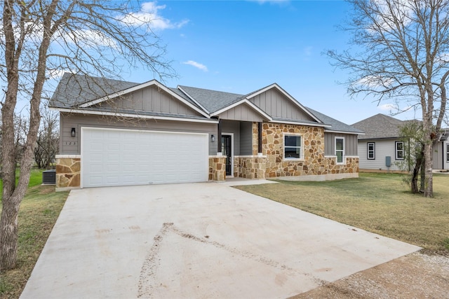 view of front of property featuring a front yard, a garage, and central AC unit