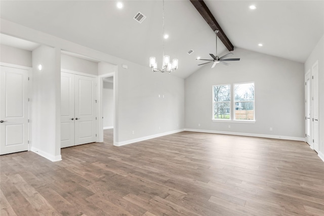 unfurnished room featuring ceiling fan with notable chandelier, light hardwood / wood-style flooring, and lofted ceiling with beams