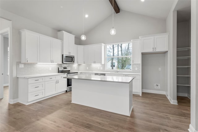 kitchen with hanging light fixtures, appliances with stainless steel finishes, and white cabinets