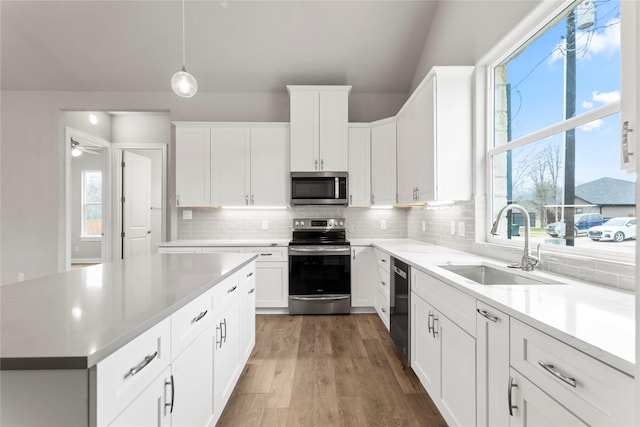 kitchen featuring sink, hanging light fixtures, white cabinets, and appliances with stainless steel finishes