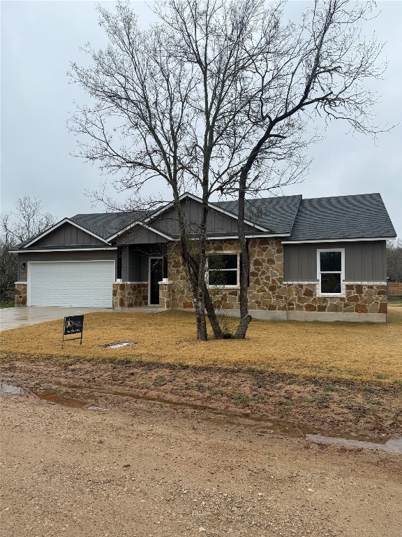 ranch-style home with a garage and a front lawn