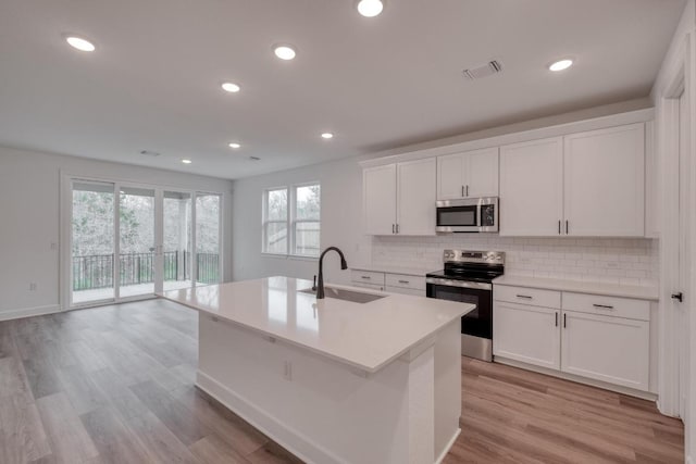 16904 Astral Ln, Manor, TX 78653 - kitchen with stainless steel appliances, plenty of natural light, decorative backsplash, white cabinetry, and recessed lighting