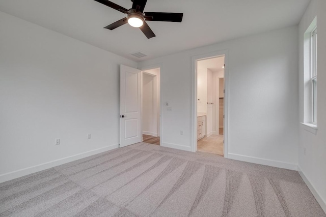 16904 Astral Ln, Manor, TX 78653 - unfurnished bedroom with light carpet, connected bathroom, and a ceiling fan