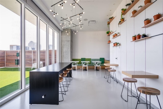 interior space featuring an inviting chandelier, concrete flooring, and a healthy amount of sunlight