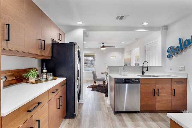 kitchen featuring light wood-type flooring, appliances with stainless steel finishes, ceiling fan, and sink