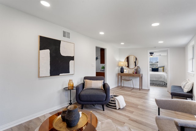 living room featuring ceiling fan and light hardwood / wood-style flooring