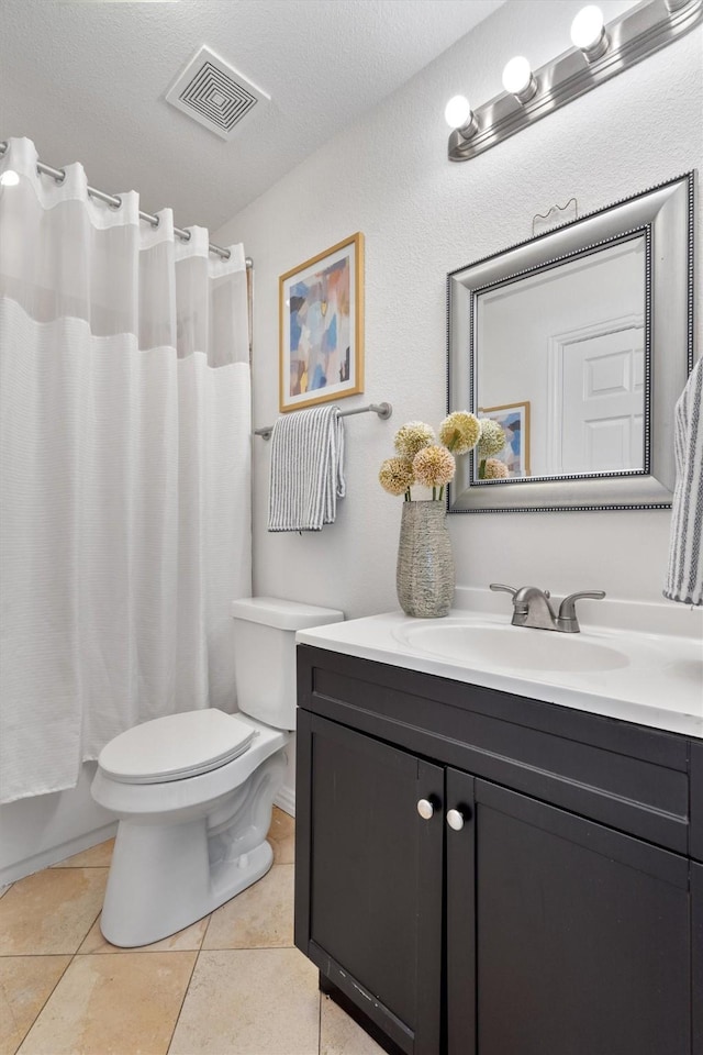 full bathroom with shower / tub combo, toilet, vanity, tile patterned floors, and a textured ceiling