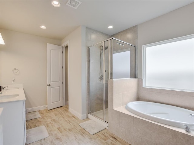 bathroom featuring hardwood / wood-style floors, vanity, and shower with separate bathtub