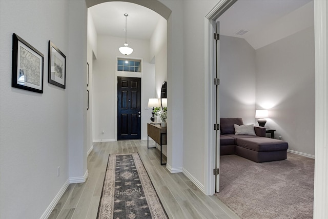 entryway with a towering ceiling and hardwood / wood-style floors