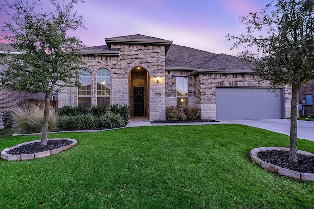 view of front of property featuring a yard and a garage