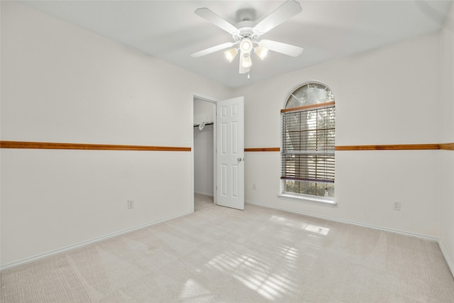 spare room featuring ceiling fan and light colored carpet