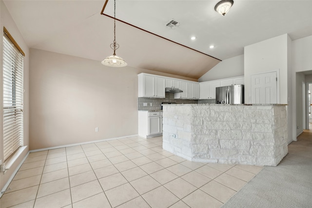 kitchen featuring white cabinetry, lofted ceiling, kitchen peninsula, backsplash, and stainless steel fridge