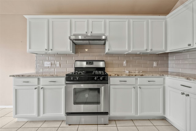 kitchen with light stone countertops, light tile patterned floors, gas stove, backsplash, and white cabinetry