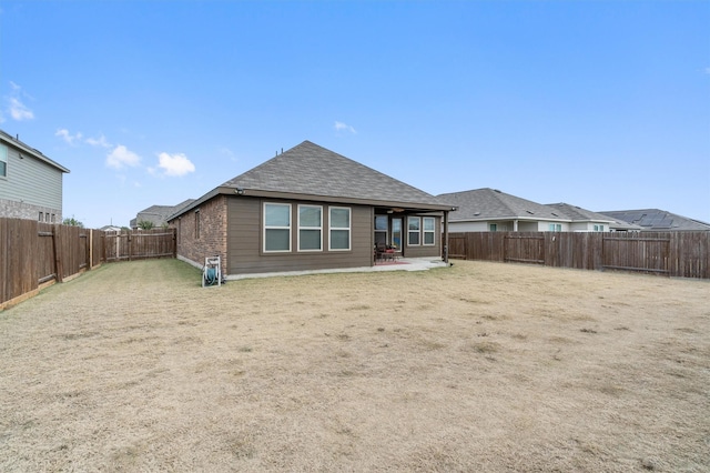 back of house with a lawn and a patio area