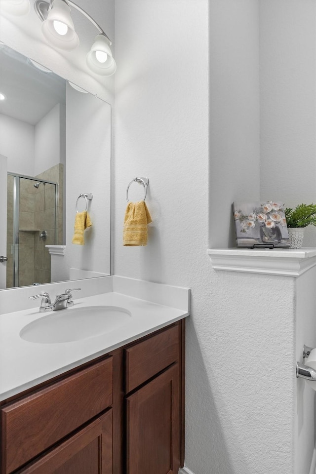 bathroom with vanity and a shower with shower door