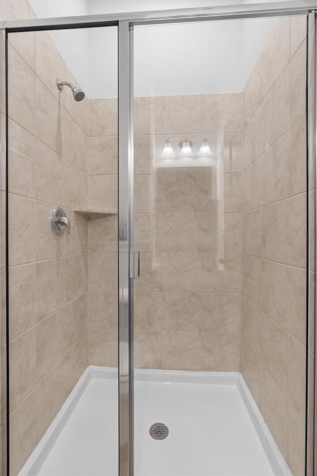 bathroom featuring a shower with door